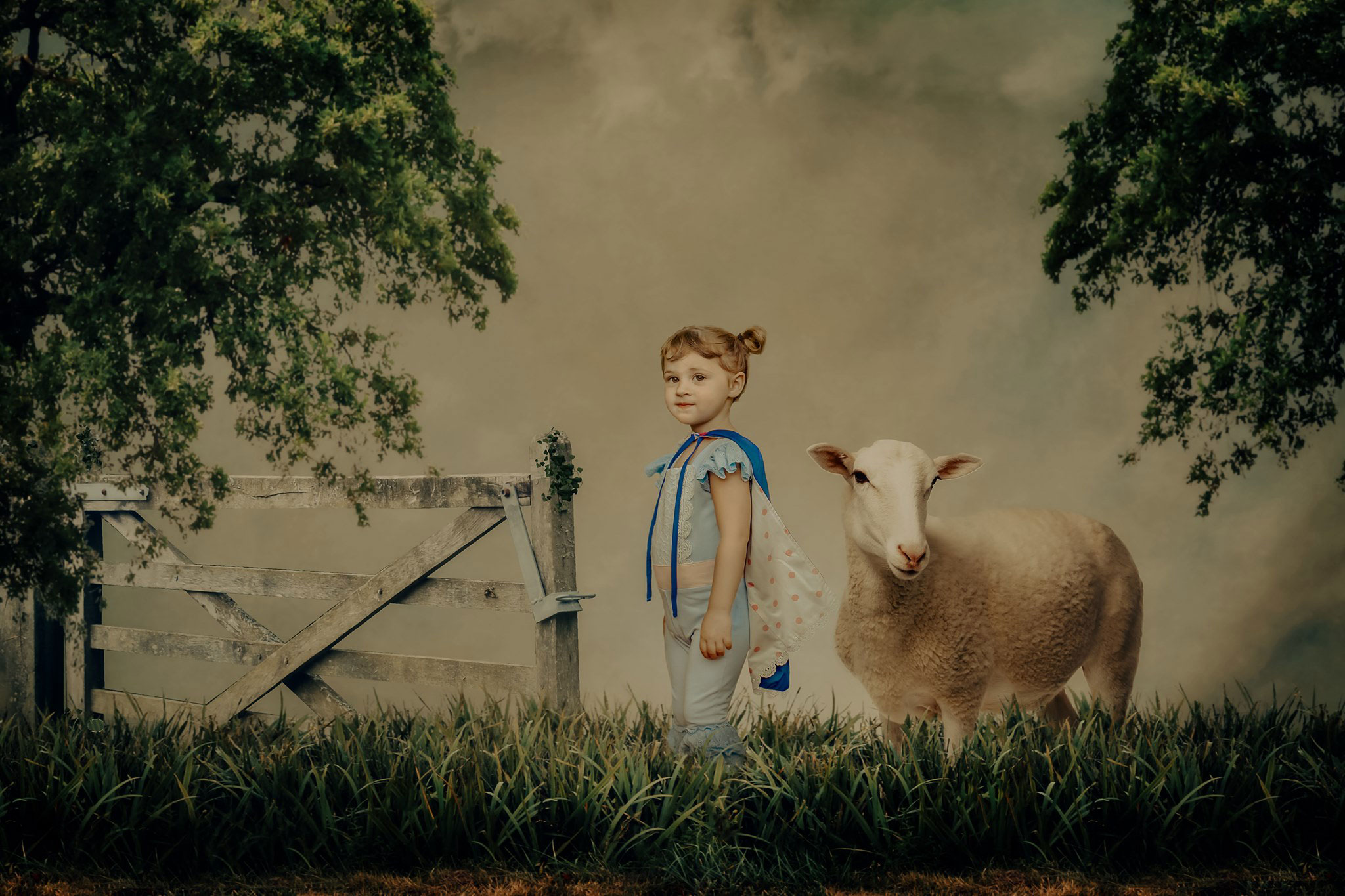 Little girl in a Bo Peep inspired blue and pink romper and cape standing next to her sheep - Wichita Toy Stores