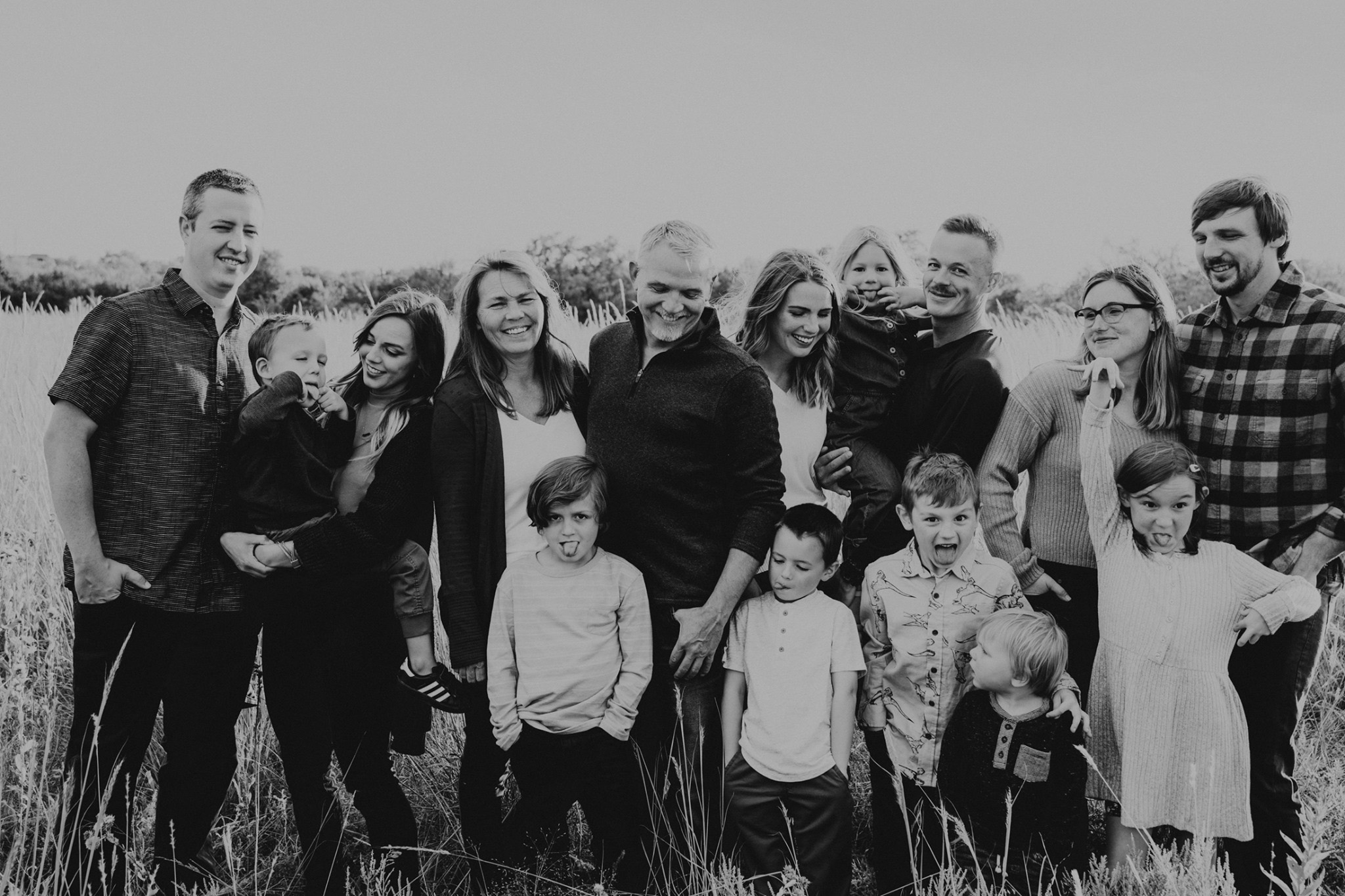 A black and white image of an extended family in a beautiful fall field in Wichita KS by Broom Tree Photo